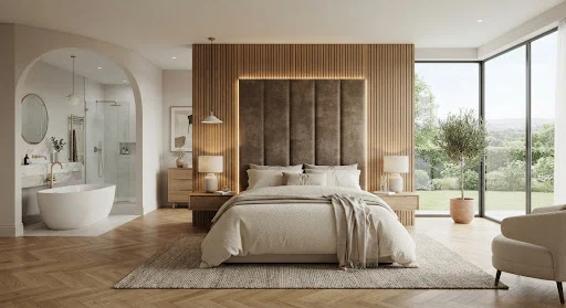 A tranquil master bedroom sanctuary featuring a custom upholstered headboard embedded into acoustic wood slats, floor-to-ceiling panoramic corner glass, soft textured boucle bedding, warm hidden ambient LED lighting, warm oak chevron floor, and distant view of an open ensuite bath.